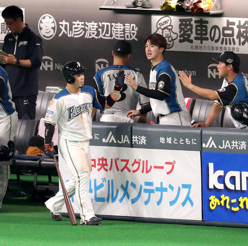 日本ハム対ロッテ　6回裏日本ハム無死一、三塁、近藤は中犠飛を放ち上沢に出迎えられる（撮影・佐藤翔太）　　