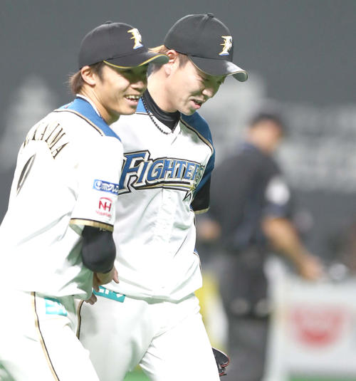 日本ハム対ロッテ　通算300ホールドを達成し中島（左）に祝福され笑顔の宮西（撮影・黒川智章）