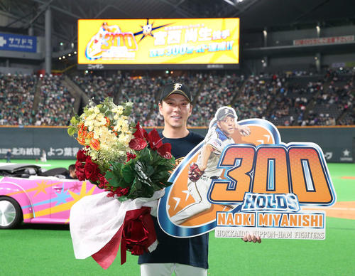 通算300ホールドを達成しボードを掲げる宮西（撮影・黒川智章）