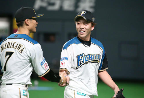 日本ハム対ロッテ　通算300ホールドを達成し西川（左）に祝福され笑顔の宮西（撮影・黒川智章）