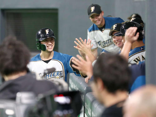 日本ハム対ロッテ　7回裏、生還しナインに出迎えられ笑顔の西川（撮影・黒川智章）