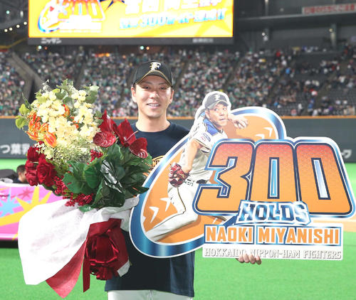 日本ハム対ロッテ　通算300ホールドを達成しボードを掲げる宮西（撮影・黒川智章）