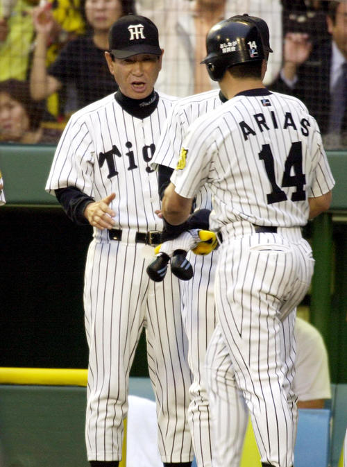 02年5月、阪神－横浜戦の1回、左中間に本塁打を放ったアリアス（右）はベンチ前で星野監督の出迎えを受ける