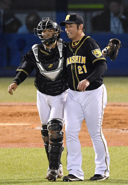 ヤクルト対阪神　完投勝利を上げ阪神梅野（左）と抱き合う岩田（左から4人目）（撮影・横山健太）