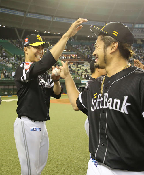 西武対ソフトバンク　8回2安打無失点で今季初勝利となった千賀（左）は抑えた森から勝利球を受け取り笑顔を見せる（撮影・河野匠）