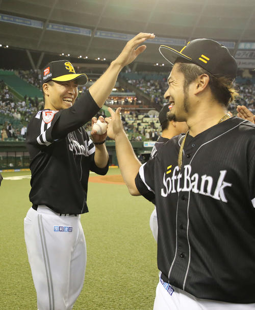 西武対ソフトバンク　8回2安打無失点で今季初勝利となった千賀（左）は抑えた森から勝利球を受け取り笑顔を見せる（撮影・河野匠）