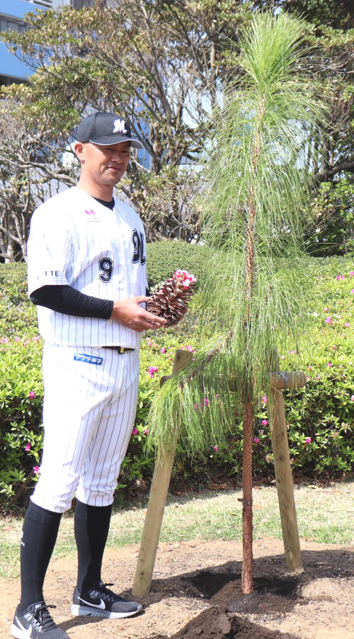 2000安打達成を記念し植樹されたダイオウショウと植樹記念パネルの前で記念撮影するロッテ福浦（撮影・久永壮真）
