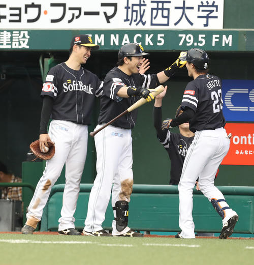 西武対ソフトバンク　5回表ソフトバンク2死一、三塁、右越え3点本塁打を放った周東（右）を笑顔で迎える、左から高橋礼、松田宣（撮影・河野匠）