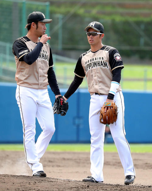 ヤクルト対日本ハム　3回途中から登板する日本ハム秋吉（左）に声をかける谷内（撮影・佐藤翔太）