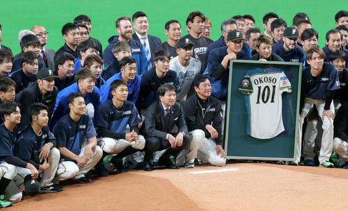 集合写真を撮る北海道日本ハムファイターズ大社氏（中央）と日本ハムナイン（2019年4月20日撮影）　　