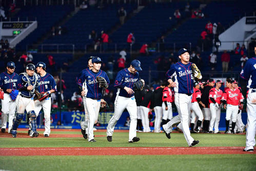ロッテ対西武　延長12回で5時間を越える試合で引き分けとなりグラウンドを引き揚げる西武ナイン（手前）と整列するロッテナイン（撮影・小沢裕）