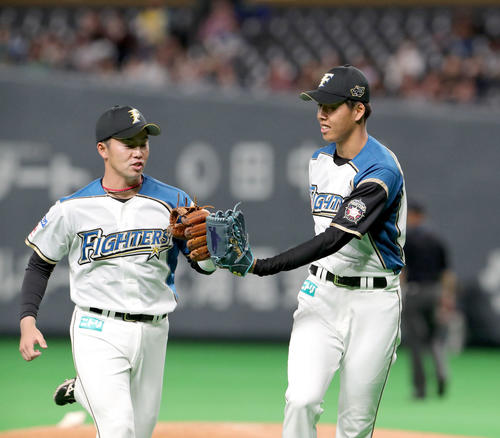タッチを交わしながらベンチに戻る日本ハム谷内（左）と杉浦（撮影・佐藤翔太）　　