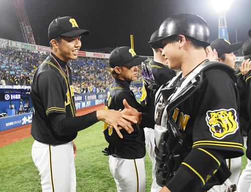 DeNA対阪神　勝利投手となった才木（左）は梅野と握手を交わす（撮影・奥田泰也）