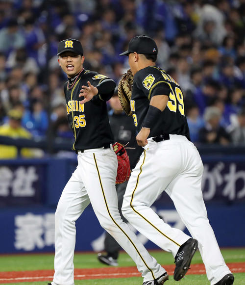 DeNA対阪神　5回裏DeNAの攻撃を抑えナバーロ（右）とタッチする阪神才木（撮影・鈴木正人）
