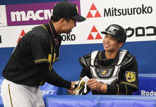 DeNA対阪神　勝利投手となった才木（左）は梅野と握手を交わす（撮影・奥田泰也）