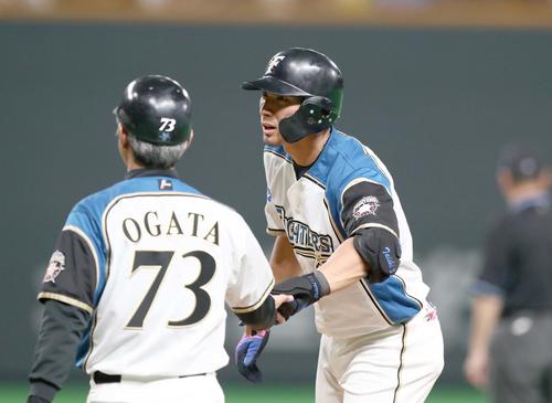 日本ハム対楽天　4回裏日本ハム無死一塁、右前打を放ち緒方コーチとタッチする大田（撮影・黒川智章）