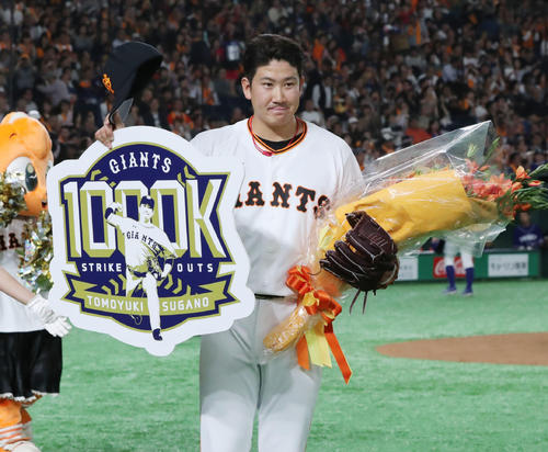 巨人対中日　7回、通算1000奪三振達成した巨人菅野はボードと花束を手にファンの声援に応える（撮影・垰建太）