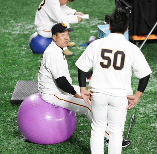 巨人対DeNA 試合前、バランスボールに乗り、戸根(右)と話す巨人原監督(撮影・林敏行)