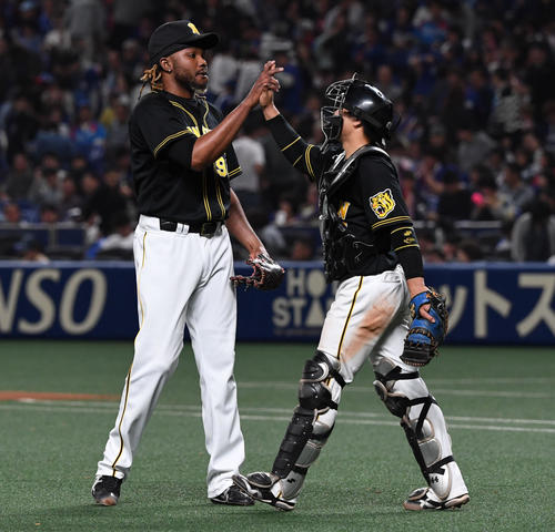 中日対阪神　中日に勝利し、ドリス（左）は梅野とタッチを交わす（撮影・奥田泰也）