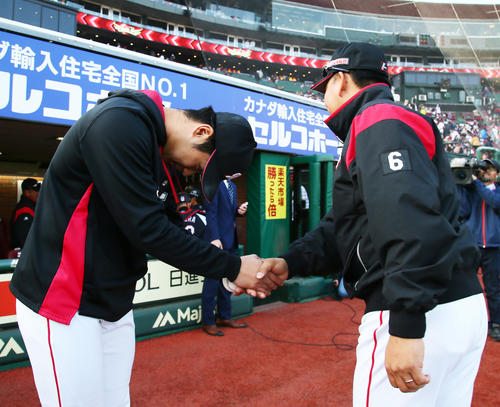 楽天対ロッテ　プロ初勝利のロッテ種市（左）は井口監督にお辞儀をしながら握手を交わす（撮影・足立雅史）