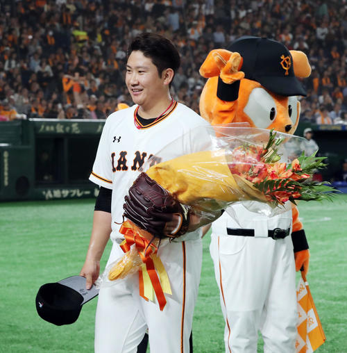 巨人対中日　7回、通算1000奪三振達成した巨人菅野は花束を手笑顔でベンチに引き揚げる（撮影・垰建太）