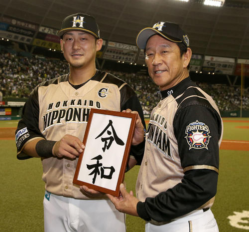 西武対日本ハム　試合終了後、令和初勝利を記念し、パネルを手に笑顔の日本ハム中田（左奥）と栗山監督（撮影・佐藤翔太）