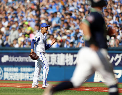 DeNA対ヤクルト　6回表ヤクルト2死二塁、村上を二ゴロに打ち取り、ガッツポーズを決める今永（後方）。手前は二塁走者青木（撮影・狩俣裕三）