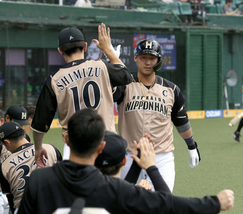 西武対日本ハム　4回表日本ハム1死、同点となる左越え本塁打を放ちチームメートに出迎えられる中田（撮影・佐藤翔太）
