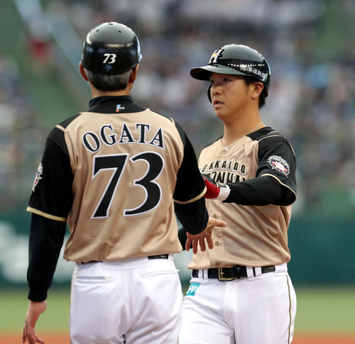 西武対日本ハム　3回表日本ハム2死、左前打を放ち緒方コーチ（左手前）とタッチを交わす平沼（撮影・佐藤翔太）