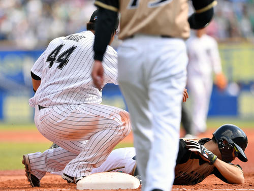 ロッテ対日本ハム　3回表日本ハム1死一塁、一塁手井上（左）に覆いかぶさられ右肩を気にする一塁走者西川（右）（撮影・滝沢徹郎）