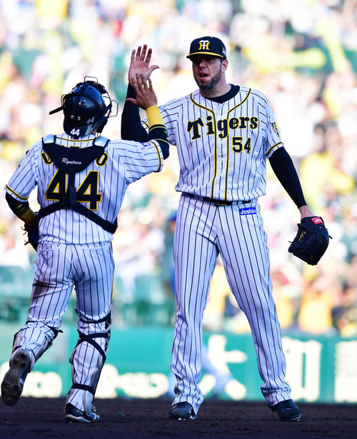 阪神対DeNA　復帰登板で完投勝利を飾ったメッセンジャー（右）は、梅野とハイタッチ（撮影・清水貴仁）