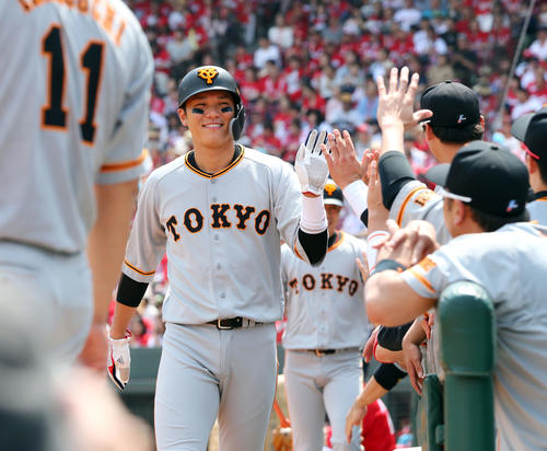 広島対巨人　1回表巨人無死一、三塁、亀井の左犠飛で生還した坂本勇は笑顔でナインの出迎えを受ける（撮影・垰建太）