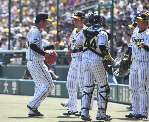 阪神対DeNA　1回高橋遥人は無失点に抑えナインとタッチを交わす（撮影・奥田泰也）