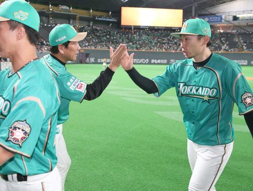 日本ハム対オリックス　試合後、金子（右）を出迎える栗山監督（撮影・黒川智章）