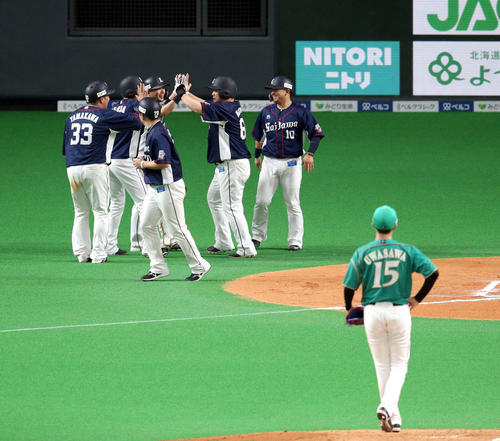 6回表西武1死満塁、逆転となる満塁本塁打を放ちチームメートに出迎えられる中村。右手前は打たれた日本ハム上沢（撮影・佐藤翔太）