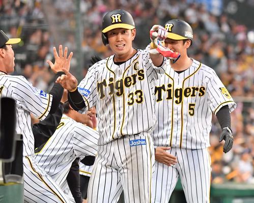 阪神対中日　2回裏阪神2死満塁、大山の適時打で生還し西勇を指さす糸原。右は近本（撮影・上田博志）