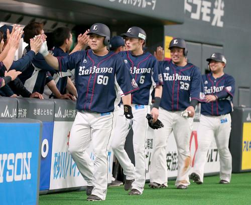 日本ハム対西武　6回表、満塁本塁打を放ちナインに出迎えられる中村（撮影・黒川智章）