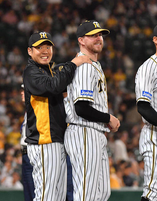中日に勝利しジョンソン（右）の肩をもむ西（撮影・上田博志）