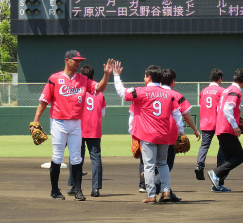 イースタン・リーグ、ヤクルト戦前のピッチセレモニーで、守備に就く習志野高時代のチームメートとハイタッチするロッテ福浦（左）