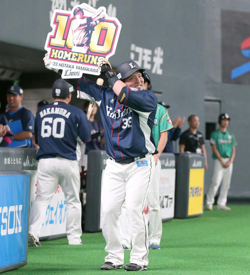 日本ハム対西武　3回表西武1死二塁、左越えに通算100号の2点本塁打を放ちボードを掲げる山川（撮影・黒川智章）