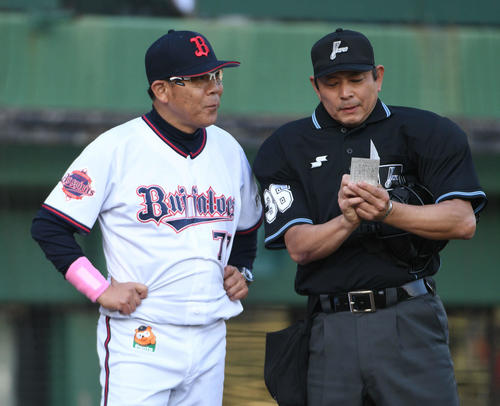 7回裏オリックスの攻撃を終え、西村徳文監督（左）は厳しい顔で真鍋勝己球審に選手交代を告げる（撮影・渦原淳）