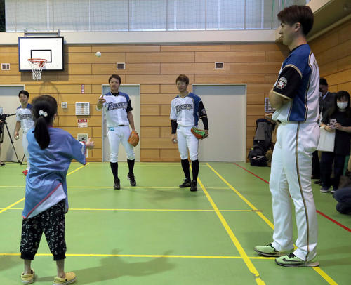 北海道大学病院内にあるひまわり分校に通う児童や生徒たちとキャッチボールをする日本ハム中島とそれを見つめる西川と上沢（撮影・佐藤翔太）