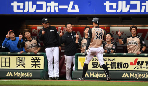 楽天対日本ハム　8回表日本ハム1死一塁、右越え2点本塁打を放った石井（手前）を1本指で迎える日本ハムナイン（撮影・横山健太）