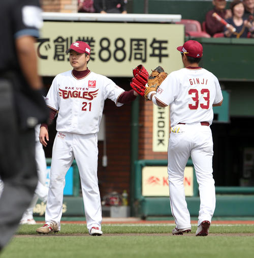 楽天対日本ハム　4回表日本ハム1死一塁、中田を遊併殺打に仕留め楽天銀次（右）とタッチを交わしながらベンチに戻る釜田（撮影・佐藤翔太）