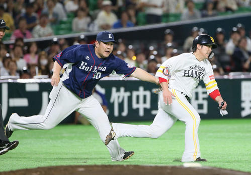ソフトバンク対西武　3回裏ソフトバンク無死二塁、牧原大成の送りバントで飛び出した甲斐拓也はタッチアウトになる。野手中村剛也（撮影・栗木一考）