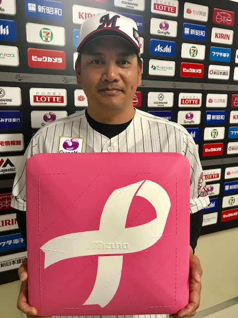 試合で使用されるピンク色のベースを手にするロッテ井口監督