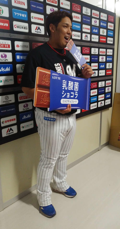 乳酸菌ショコラ1年分を贈られ、チームを代表して受け取ったロッテ井上は恒例のかぶりつきポーズ