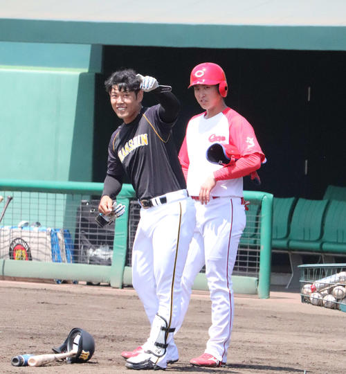 ウエスタン・リーグ試合前、談笑中に指を差す阪神原口と広島堂林（撮影・前原淳）