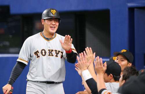 中日対巨人　6回の攻撃を終え適時打を放った巨人岡本（左）はナインと笑顔でタッチを交わす（撮影・垰建太）