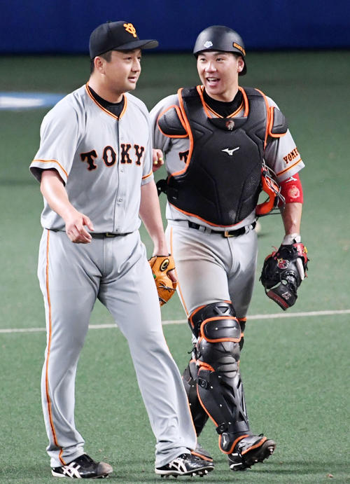 中日対巨人6回戦　9回を締めくくった沢村拓一（左）は炭谷銀仁朗と笑顔で話す（撮影・前岡正明）